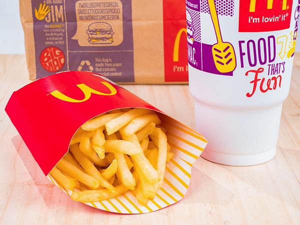 McDonald's fries, a soda and a bag on a table. 