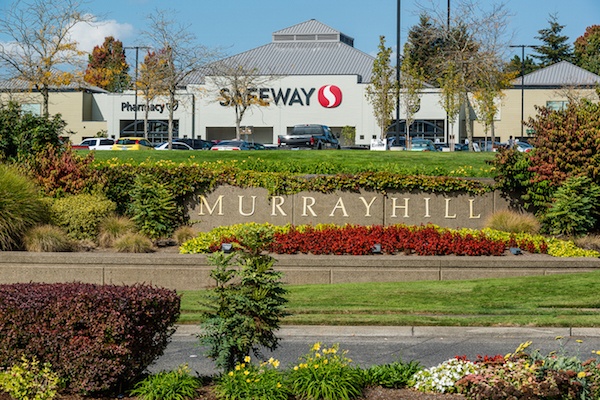 Murrayhill Marketplace signage surrounded by flowers and plants. 
