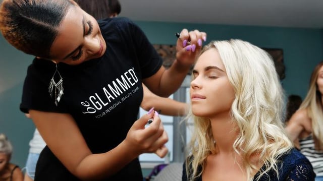 A beGlammed employee applying makeup to a customer. 