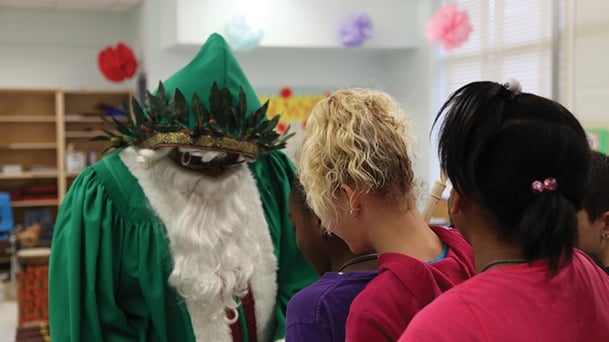 students looking at a green santa like costume for their upcoming production