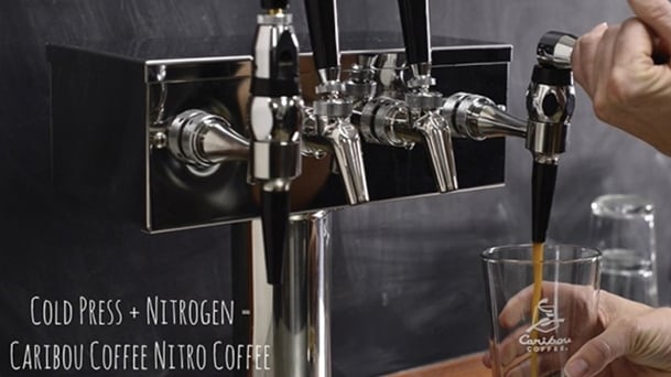 nitro coffee bar tap with coffee being poured into glass cup