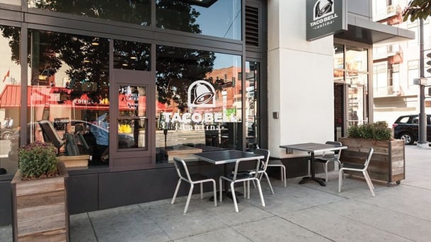 Taco Bell store front in downtown area with sleek outdoor seating