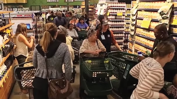 feature-16x9-whole-foods-opening.jpg Whole Foods Grand Opening with aisles filled with customers and their carts
