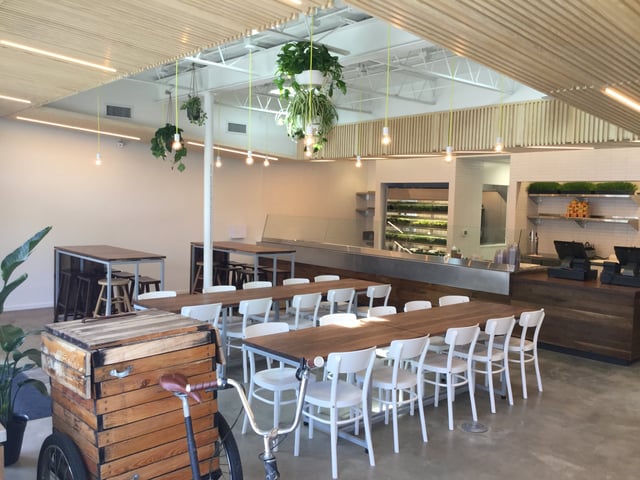 inside of a restaurant with white and wood furniture