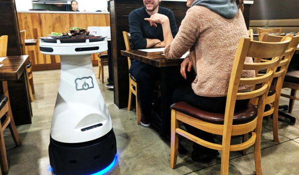 robot server providing food to guests at restaurant