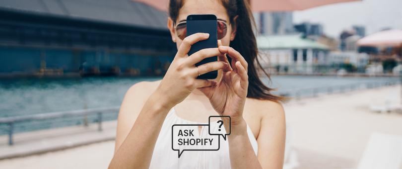 woman looking at phone while outside with a Shopify icon on the image