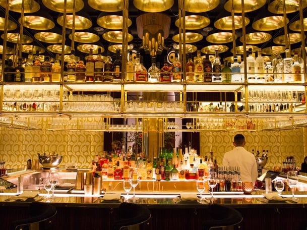 A bar with bright lighting under the bottles of liquor. 