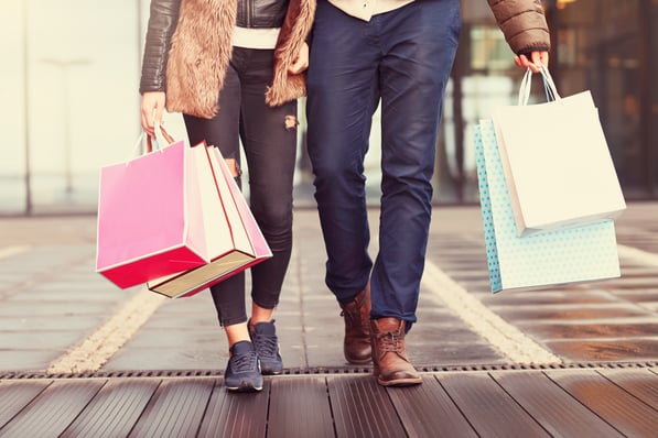 Two shoppers carrying shopping bags. 