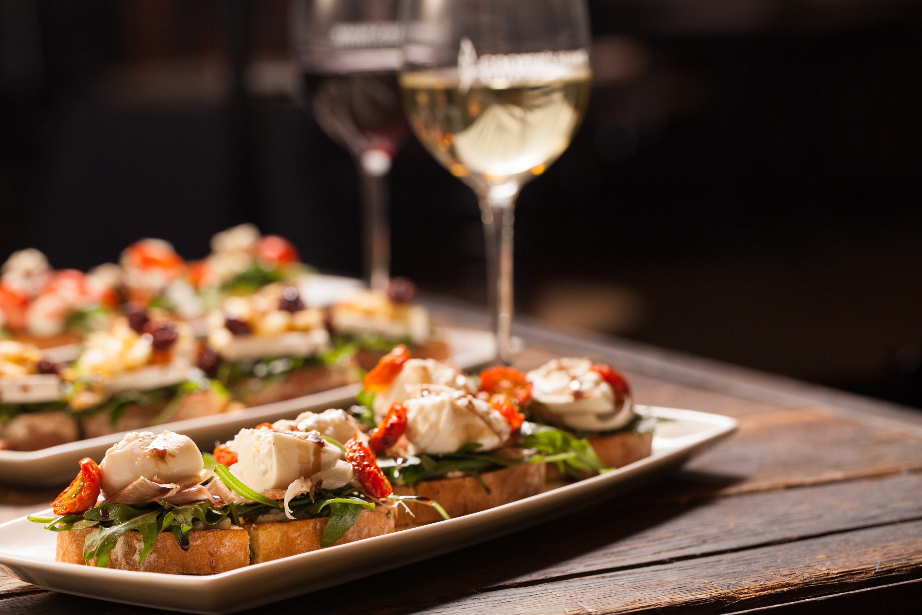 Upclose image of appetizer and wine glasses 